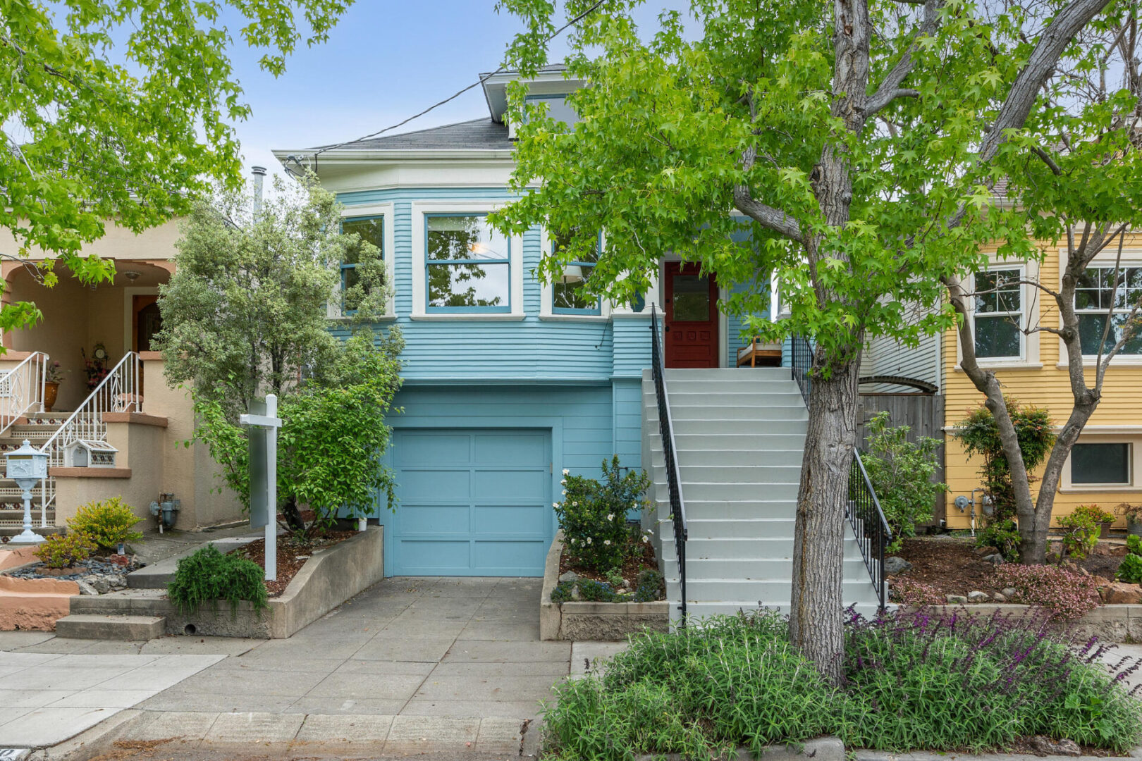 A blue house with steps leading to the front door.